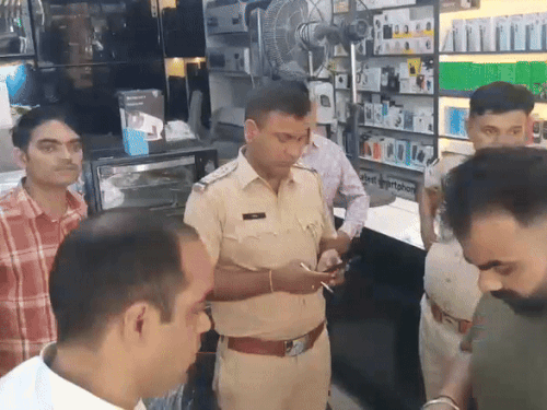दुकान पर जांच करती पुलिस व मौके पर मौजूद दुकान मालिक व अन्य।