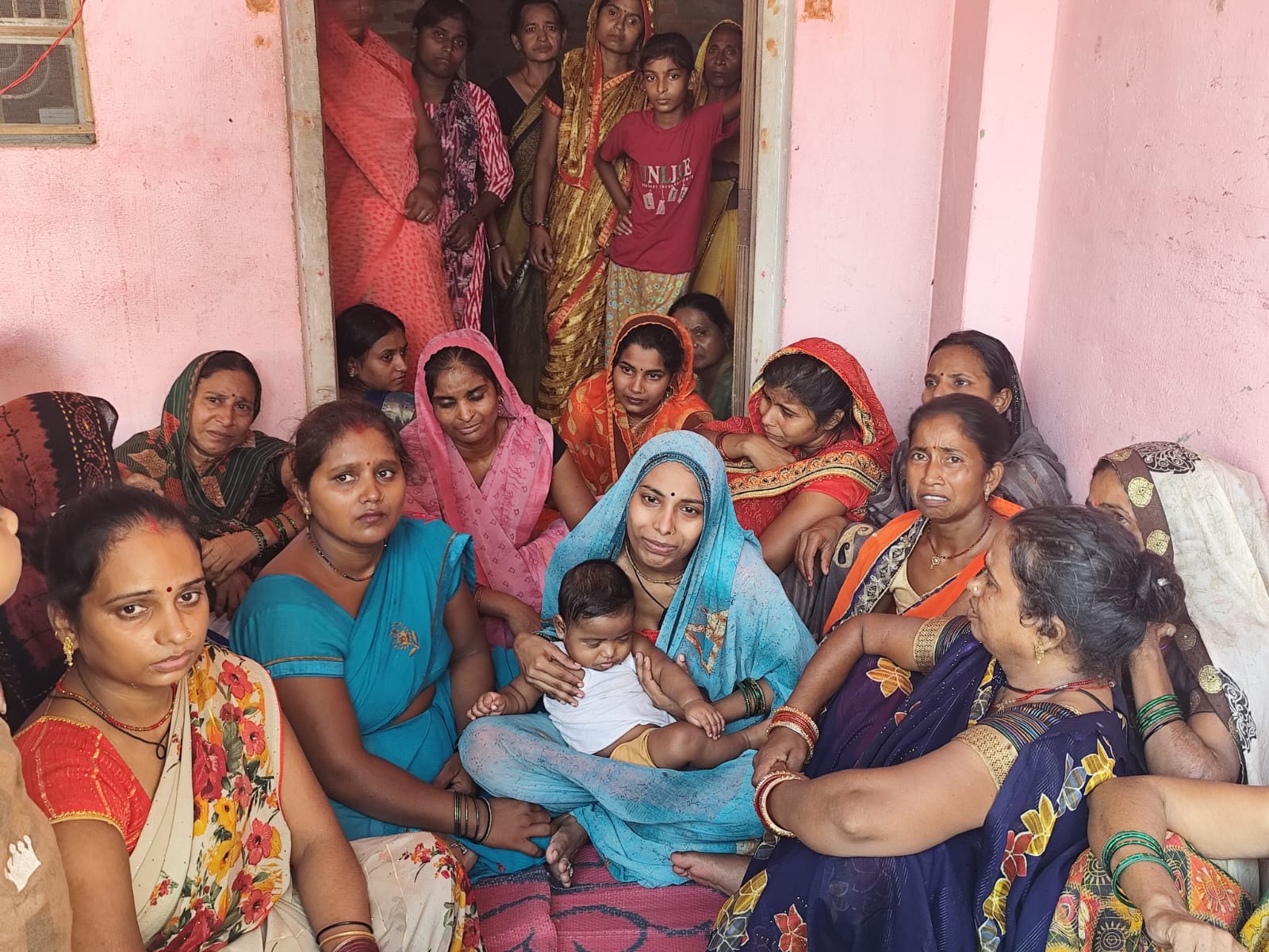 बच्चे के साथ बैठी उमेश की पत्नी। रोते बिलखते परिजन।