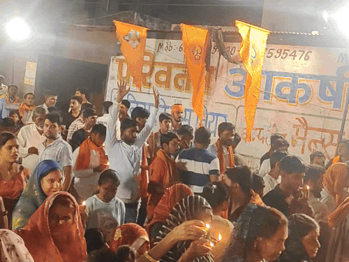हनुमान चालीसा पाठ के अंत में आरती करते भक्त।