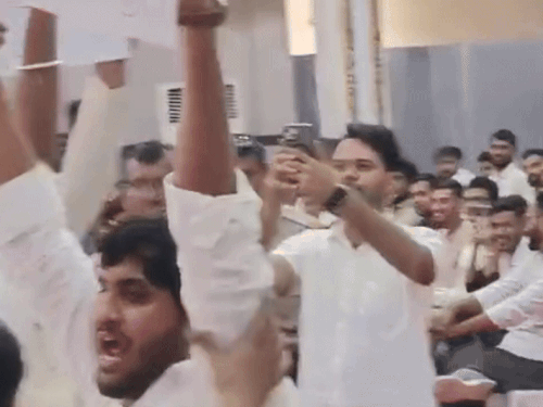 राज्यसभा सांसद को तख्तियां दिखाते हुए छात्र।