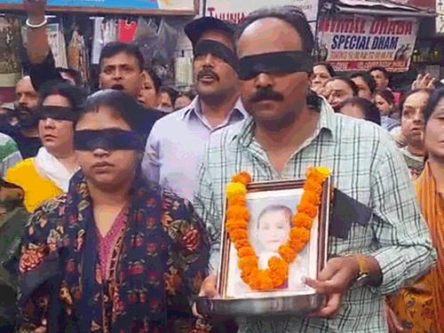 शिमला के लोअर बाजार में रोष रैली के दौरान आंखों पर काली पट्टी बांधे हुए युग के माता-पिता।