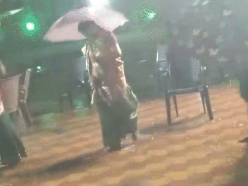 देवेन्द्र नगर सेक्टर-3 दुर्गा मैदान में बारिश के बीच छाता लेकर गरबा करती महिलाएं।