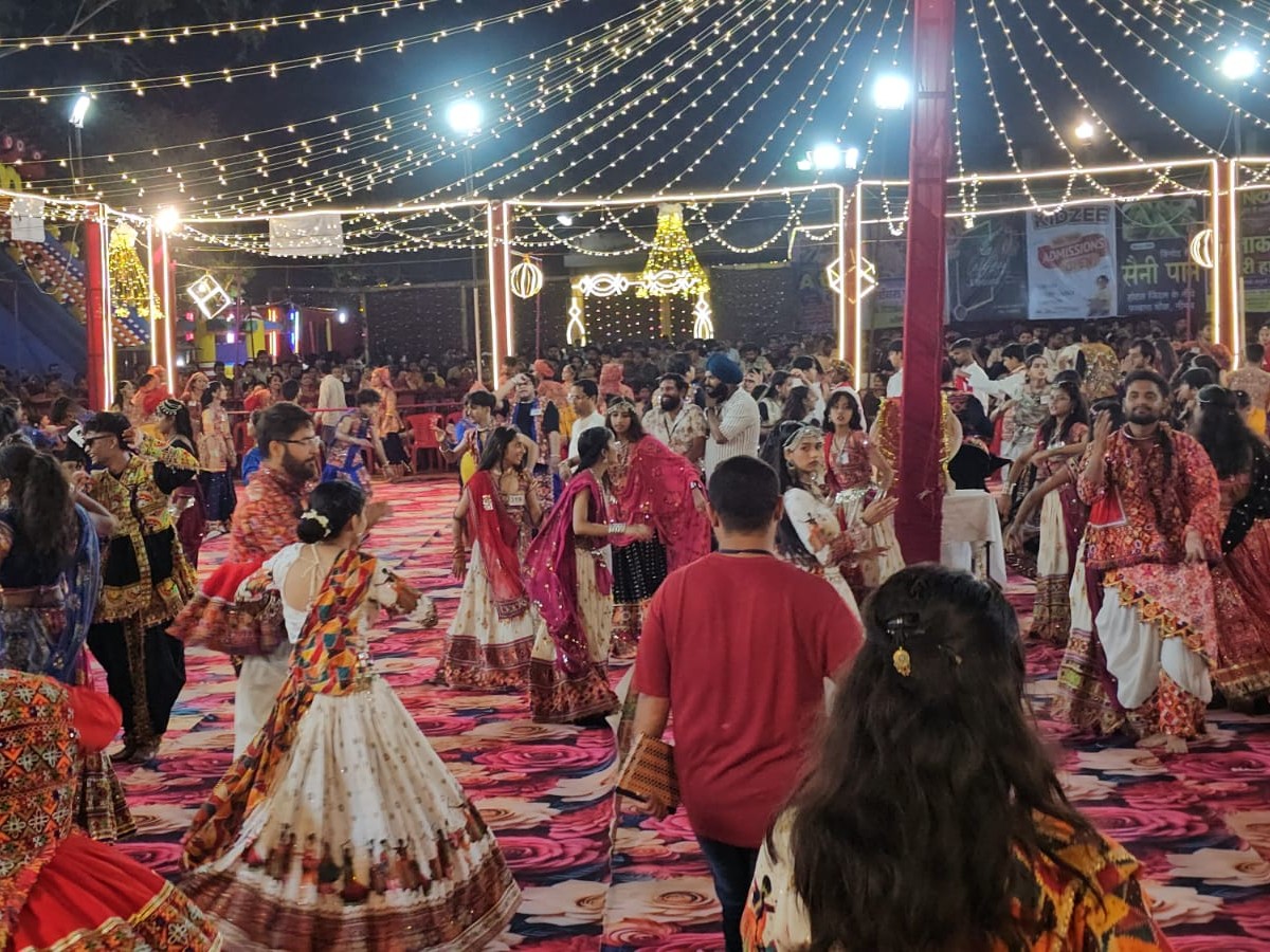 दुर्गा पंडाल में गरबा खेलते श्रद्धालु।