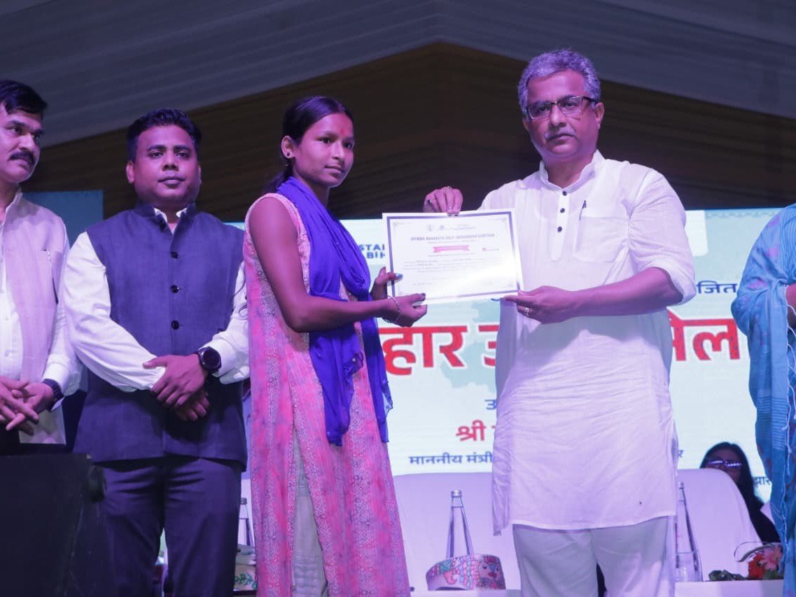 युवती को मंत्री दे रहे सर्टिफिकेट।