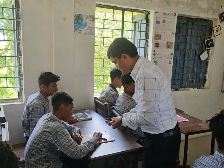 बच्चों को पैन बांटते हुए कलेक्टर।