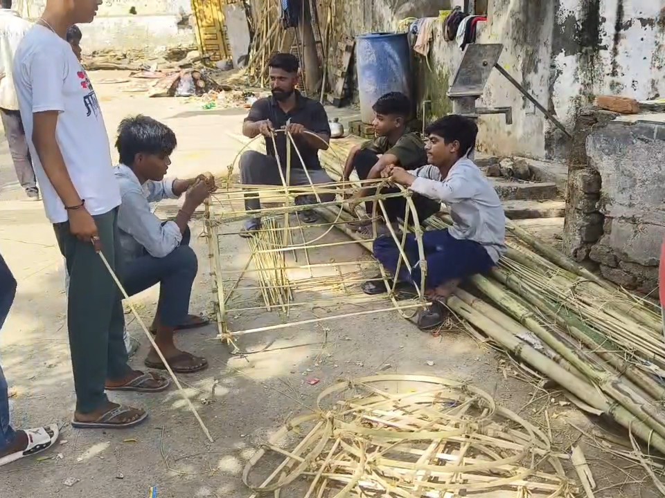 युवा कारीगर बांस की लकड़ी, कागज और आटे की लेई का उपयोग करके पुतले बनाते हैं।
