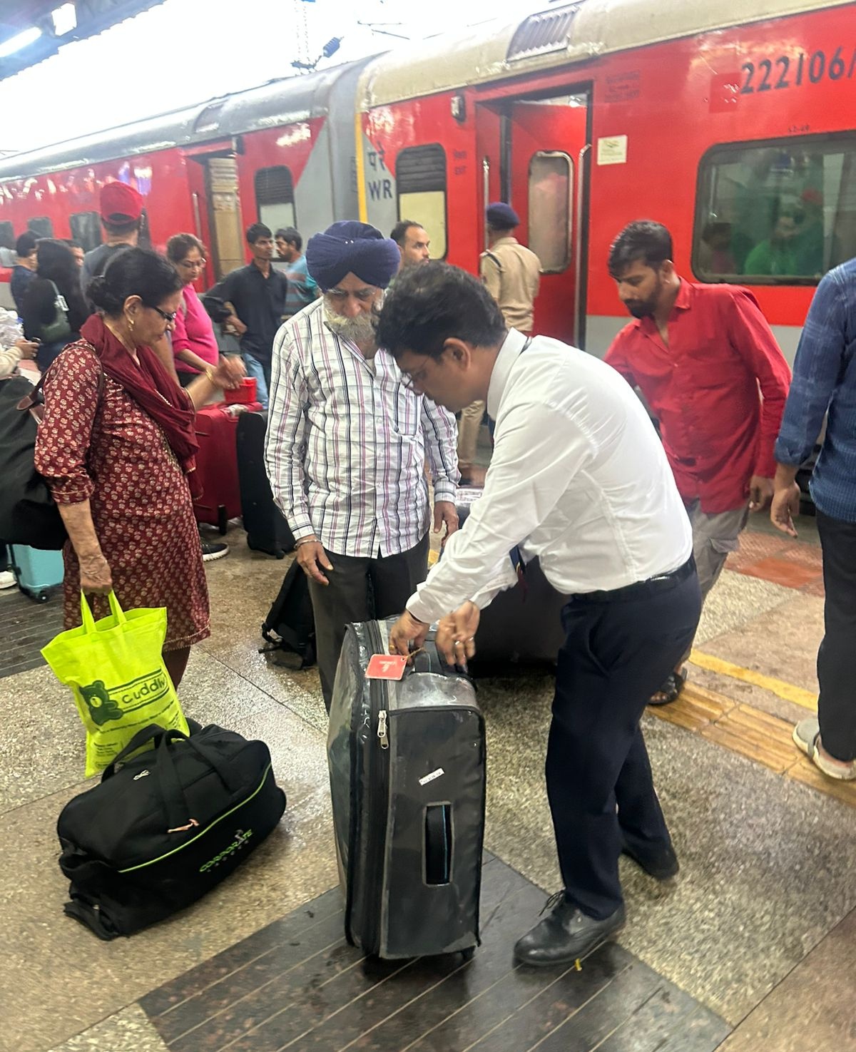 यात्रियों का सामान रेल से उतारने में उनकी मदद करते कर्मी।
