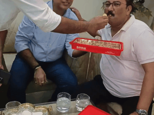 एशिया कप जीतने पर अभिषेक के पिता को मिठाई खिलाते हुए पड़ोसी।