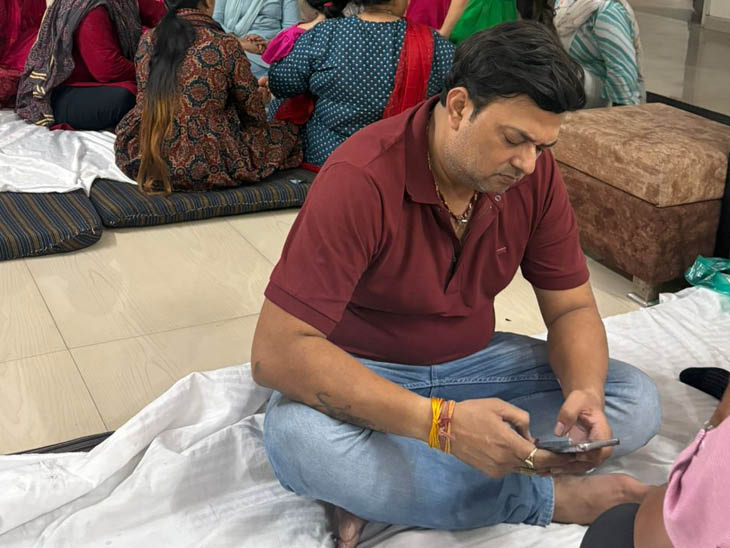 जितेंद्र शर्मा मोबाइल में बच्चों की फोटो को देखते हुए।