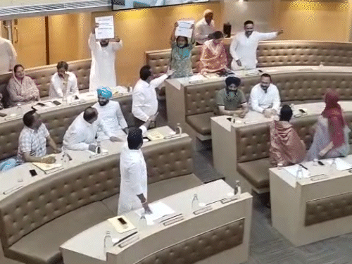 पर्चे दिखाकर मीटिंग में हंगामा करते कांग्रेस और आम आदमी पार्टी के पार्षद।