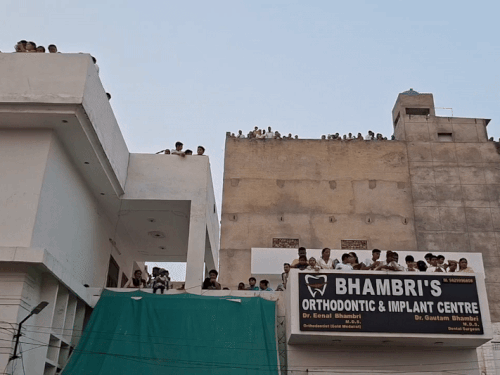 रावण के दहन को देखने के लिए छत्तों पर चढ़े लोग।
