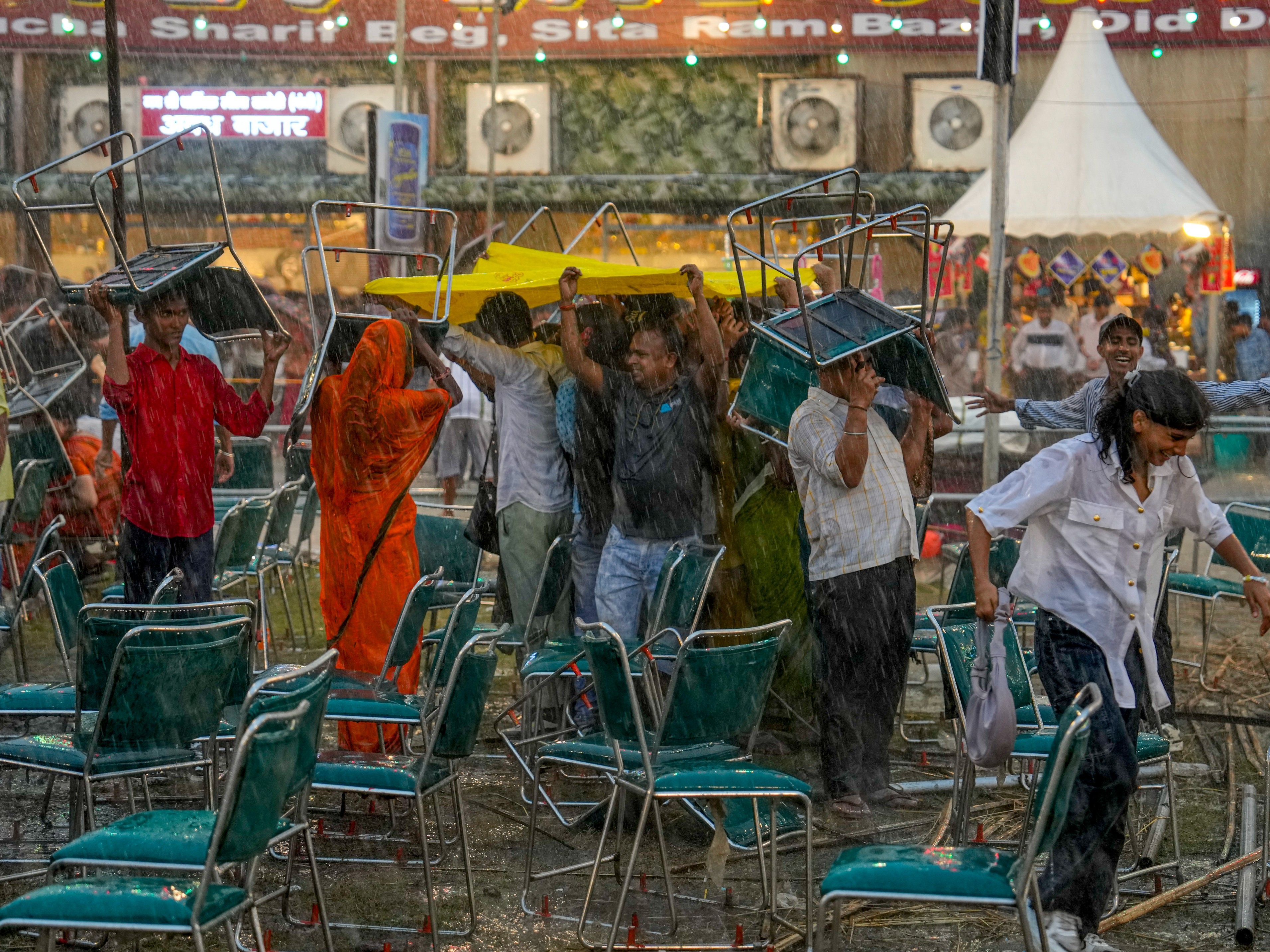 It started raining during Ravana combustion in New Delhi, the audience was seen trying to avoid getting wet with the help of chairs. - Dainik Bhaskar