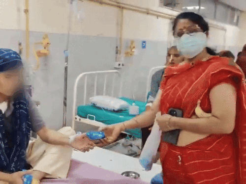 जयपुर के RUHS में कैंसर पीड़ित को बिस्किट का पैकेट देकर महिला ने फोटो खिंचाई। फोटो खिंचने के बाद पैकेट वापस ले लिया।