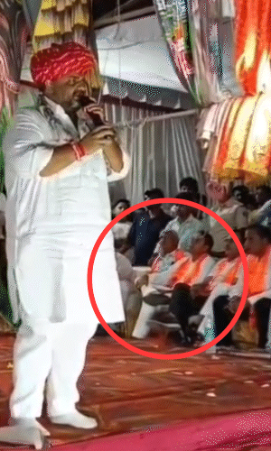 विधायक गोपीचंद मीणा रामलीला आयोजक प्रकाश गुजराती को लात मारकर दूर जाने के लिए कहते हैं।