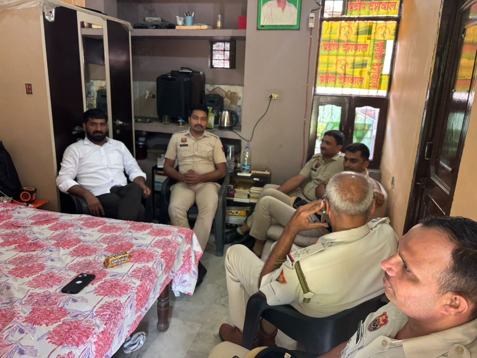 Police officer sitting at Pradeep Deshwal's house in Sector 14 of Rohtak.