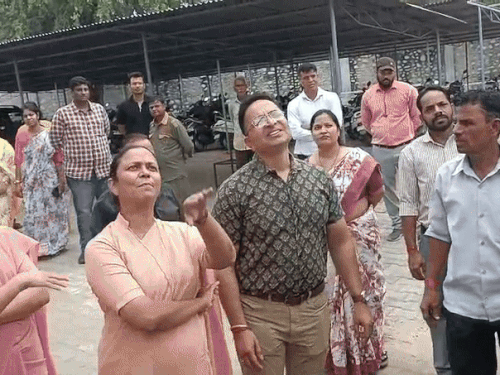 गेट पर चढ़कर विरोध प्रकट करते कार्यकर्ता, समझाइश करता स्टाफ।