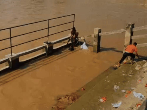 नहर में मां बेटी को बाहर निकालते राहगीर।