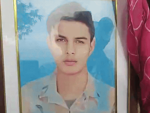 अपने बेटे की फोटो को लेकर जिला सचिवालय में बैठी मां की फाइल फोटो।