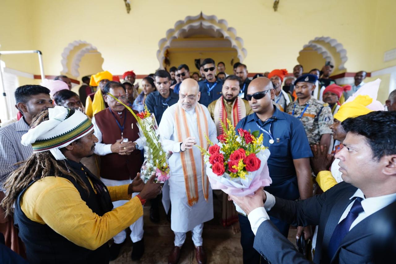 People welcoming Shah with a bouquet.