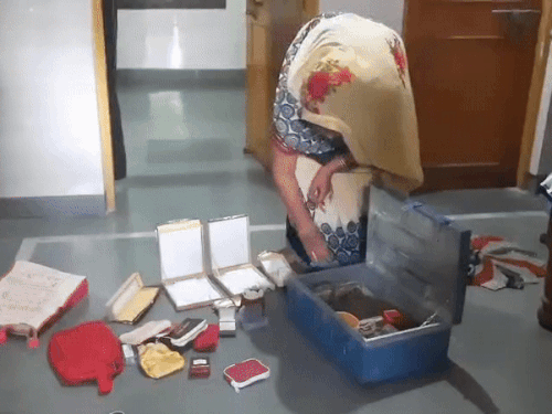 सोने और चांदी के जेवर का खाली बक्सा दिखाती महिला
