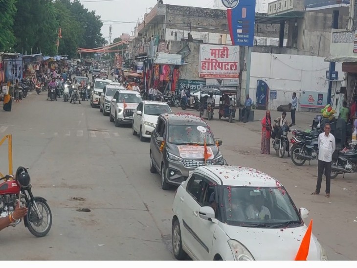 धर्म यात्रा में कतारबद्ध गुजरते वाहन।