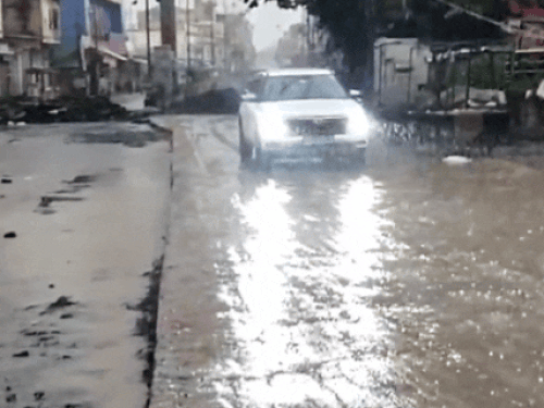 सीकर में बारिश के दौरान जाट बाजार एरिया से गुजरती गाड़ियां।