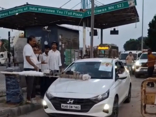 चौमूं (जयपुर) के टाटियावास टोल पर पूर्व मंत्री राजेंद्र गुढ़ा बैरियर को उठाकर कार निकालते हुए।