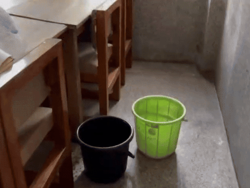 छत से टपकता पानी फर्श पर लगा रखी बाल्टिया