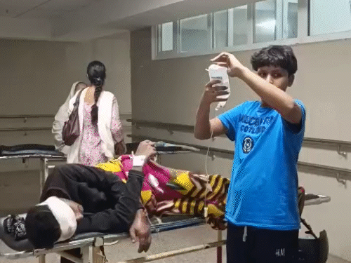 The patient is being treated on a stretcher. The child has been given a glucose bottle.