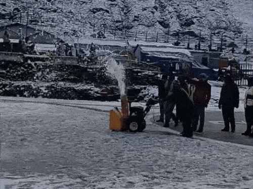 After snowfall in Kedarnath, a worker removes the snow accumulated on the helipad with a machine. - Dainik Bhaskar