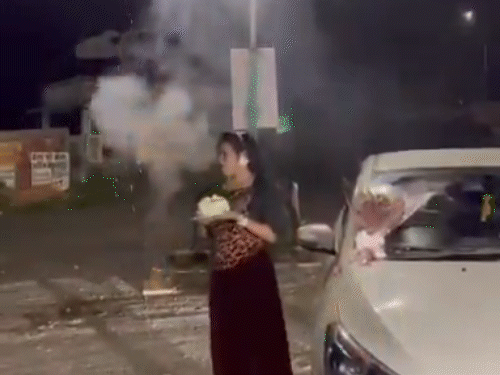 आतिशबाजी के दौरान भाजपा नेता की पत्नी हाथों में केक पकड़े नजर आई।