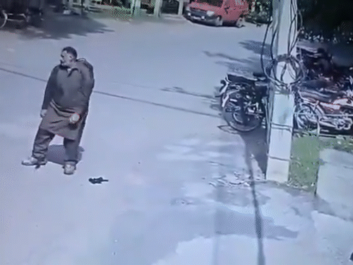 पुलिस की गोली लगने के बाद हमलावर सड़क पर गिर जाता है।