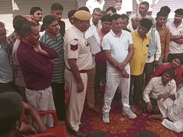 पुलिसकर्मी कर रहे व्यापारियों से समझाइश की कोशिश।