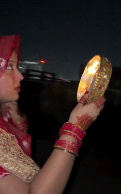 Jyoti Singh, dressed in red, looked at the moon through a sieve.