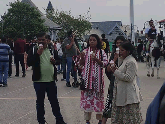 शिमला के रिज पर सॉफ्टी का आनंद उठाते हुए टूरिस्ट।