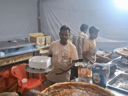 बिना ग्लव्स पहने खाने का सामान तैयार करते स्टॉल कर्मी।