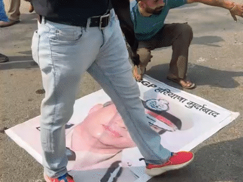छुट्‌टी पर भेजे हरियाणा के DGP कपूर के फोटो पर चप्पल मारते प्रदर्शनकारी। इस दौरान प्रदर्शनकारियों की पुलिस से भी बहस हुई।