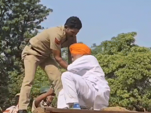 ट्रैक्टर ट्रॉली पर बैठे रोते हुए चढ़ूनी वहीं पुलिसकर्मी उन्हें हिरासत में लेते हुए।
