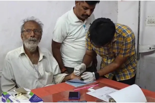 एक मृतक के परिवार के बुजुर्ग से का ब्लड सैंपल लेती टीम।