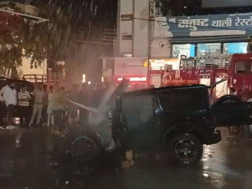 अग्रसेन चौक पर जलती थार कार की आग बुझाते दमकल कर्मी