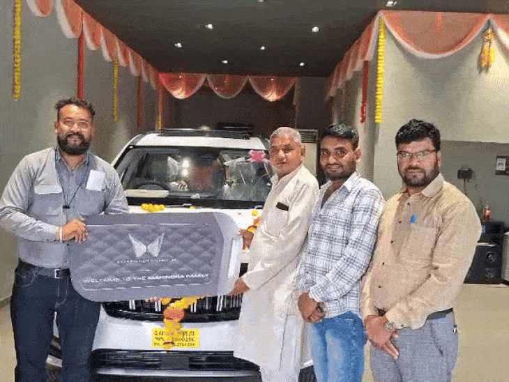 शोरूम से कार खरीदते हुए लोग।