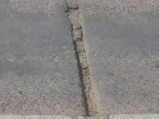 सड़क के बीच में बनी सरफेस में भी दरारें हैं।