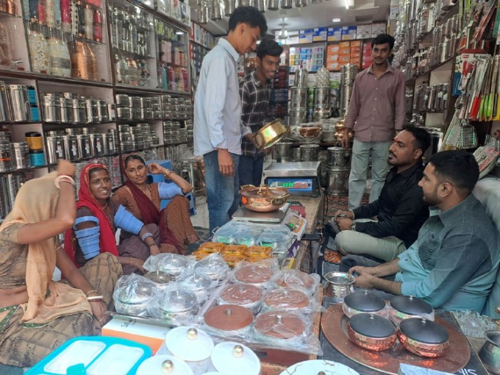 पाली में बर्तनों की शॉप पर धन तेरस को खरीदारी करते हुए लोग।