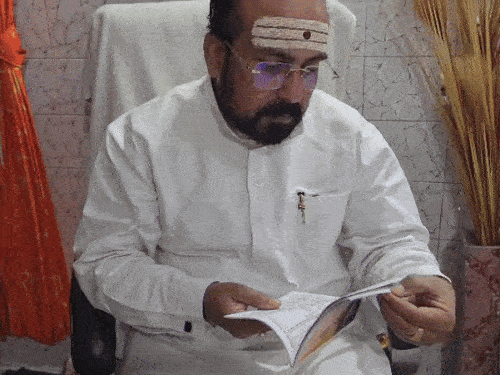 पंचांग देखकर जानकारी देते तीर्थ पुरोहित उज्जवल पंडित
