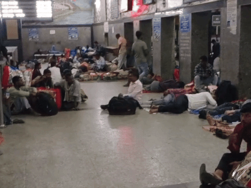रेलवे जंक्शन के टिकट काउंटर के बाहर लेटे यात्री।