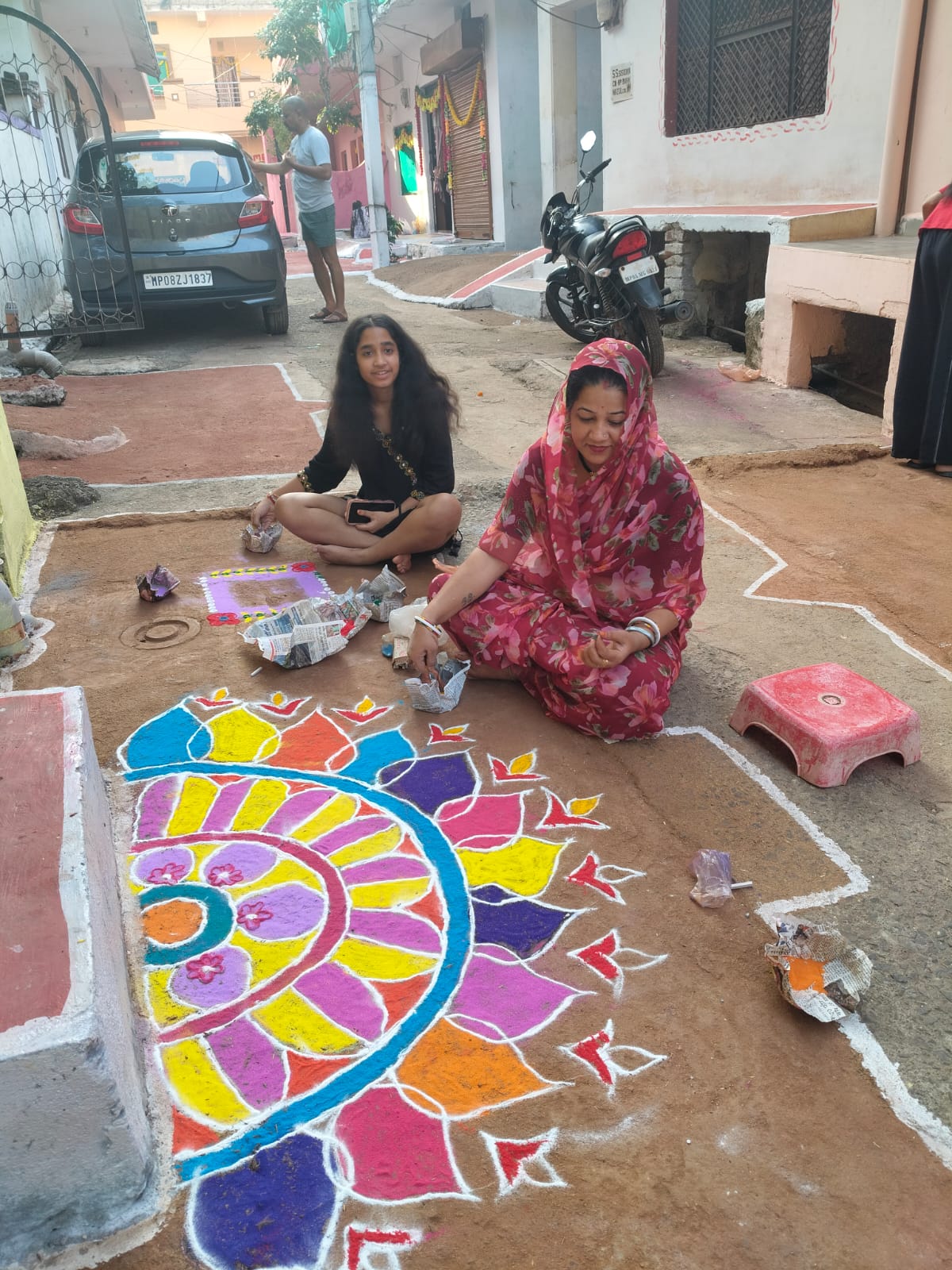 अपने घर के आगे रंगोली बनातीं राधिका चौहान।