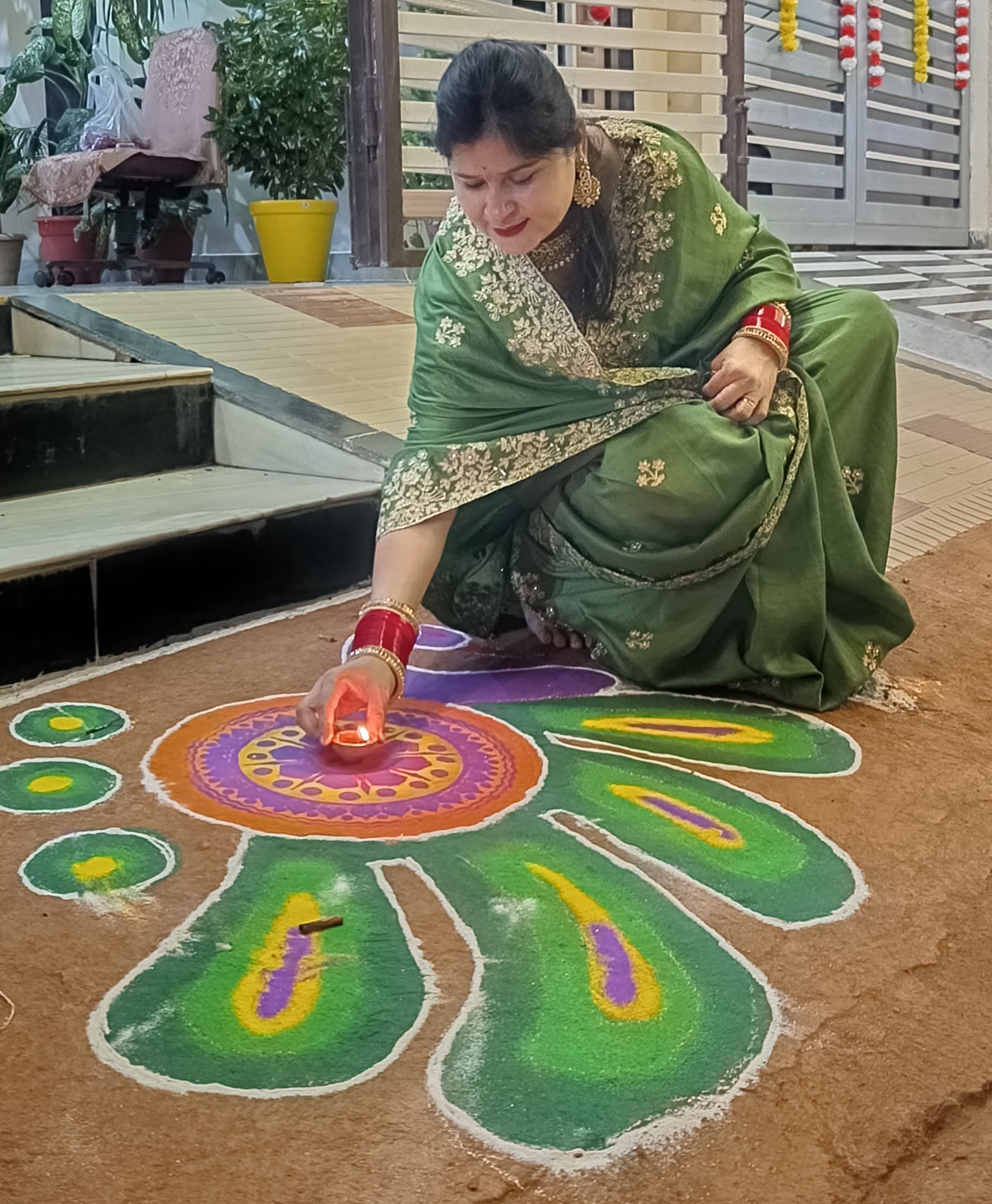 पूजन के बाद दीए रखतीं रजनी ओझा।