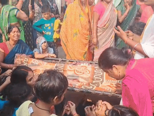 खाट पर हनुमान का शव रखकर महिलाएं रोड पर बैठ गईं। पुलिस पर कार्रवाई की मांग की।