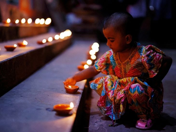 बांग्लादेश के ढाका में दिवाली के मौके पर बच्ची दीये रखती हुई।