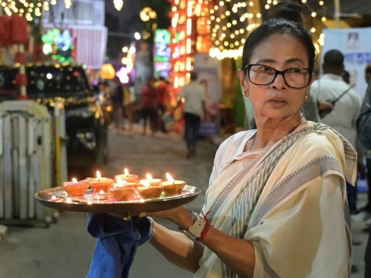 CM ममता बनर्जी कोलकाता के कालीघाट में अपने घर पर काली पूजा से पहले दीये रखती हुईं।
